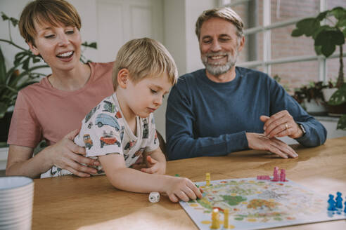 Parents playing board game with son at home - MFF06656