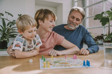 Eltern spielen Brettspiel mit Sohn, der zu Hause wegschaut - MFF06657