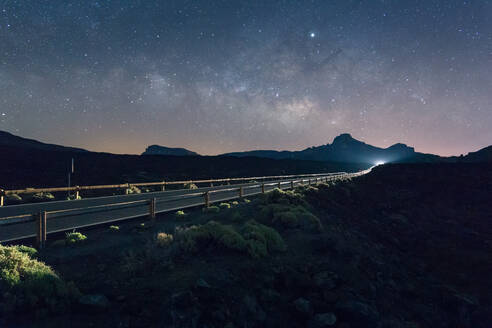 Erstaunliche Szenerie einer beleuchteten Autobahn im Hochland bei Nacht unter Sternenhimmel auf Teneriffa in Langzeitbelichtung - ADSF17110