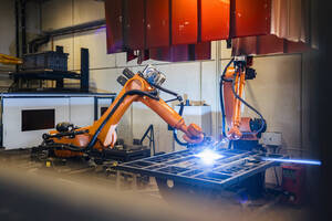 Orange robotic arms welding in industry - DIGF12931