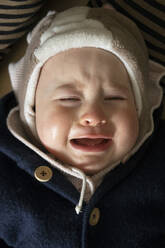 Baby weint im Liegen im Haus - SKF01594