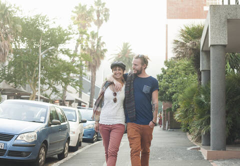 Paar geht mit Arm um auf der Straße, lizenzfreies Stockfoto