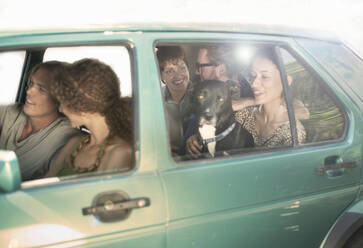 Smiling male and female friends sitting in car during road trip - AJOF00405