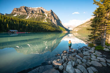 Wanderer steht am Rande des Lake Louise im Banff National Park - CAVF89888