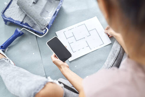 Young woman working on design while using mobile phone at home - BSZF01739