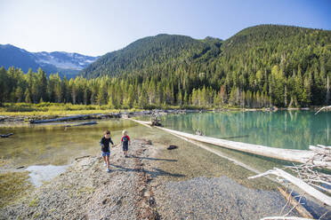 Two boys explore and play no remote beach in British Columbia, Canada - CAVF89913