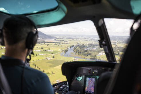 Hubschrauberpilot beim Blick auf das Ackerland im Fraser Valley. - CAVF89917