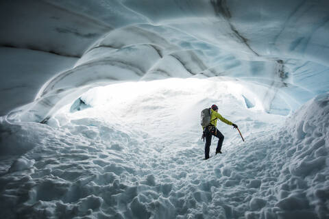 Climber, Paul Mcsorley, explores an ice cave on a mountaineering trip. stock photo