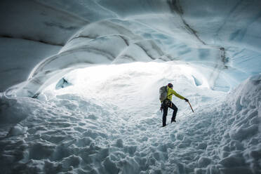 Der Bergsteiger Paul Mcsorley erforscht eine Eishöhle auf einem Bergsteigerausflug. - CAVF89919