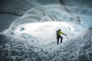 Der Bergsteiger Paul Mcsorley erforscht eine Eishöhle auf einem Bergsteigerausflug. - CAVF89919