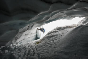 Bergsteiger beim Abseilen in Gletscherspalte / Gletschereishöhle. - CAVF89921