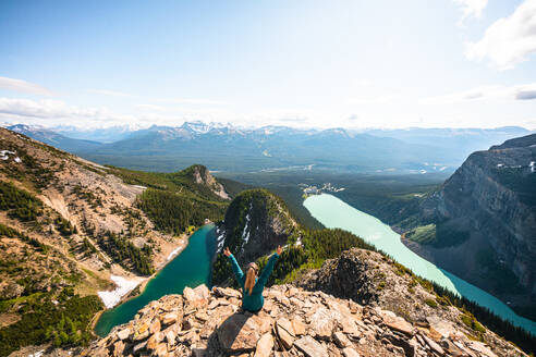 Wanderer feiert über Lake Louise und Lake Agnes am Teufelsdaumen - CAVF89941