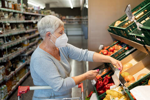 Caucasian elderly woman with white hair shopping in supermarket stock photo