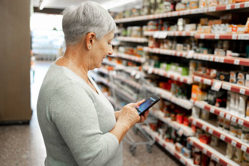 Caucasian elderly woman with white hair shopping in supermarket - CAVF89976