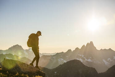 Tranquil scene of backpacker hiking across mountain summit. - CAVF89987