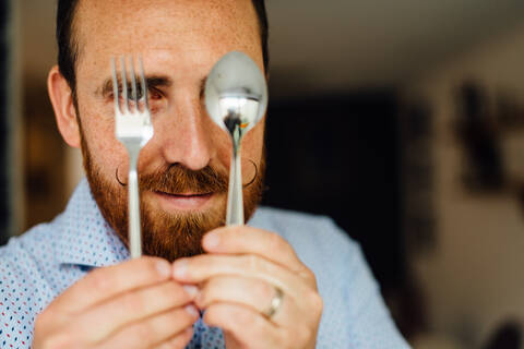 Close up portraits of man with moustache holding fork and spoon stock photo