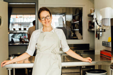 Küchenchefin lächelt in der Restaurantküche in die Kamera - CAVF90006