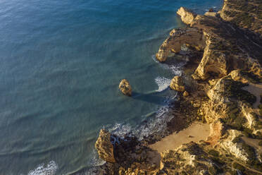 Portugal, Bezirk Faro, Drohnenansicht der Klippen und des Strandes von Praia da Marinha in der Morgendämmerung - RUEF03116