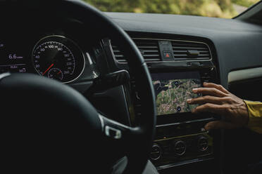 Hand of woman checking digital maps in car during vacations - DMGF00207