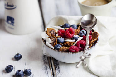 Bowl of homemade cereals with coconut, raspberries and blueberries - SBDF04400