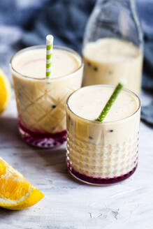 Gläser mit frischem Fruchtsmoothie mit Orangen, Bananen, Joghurt und Grenadine - SBDF04403