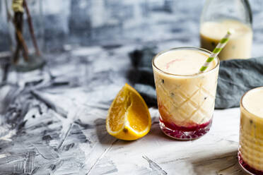 Glasses of fresh fruit smoothie with oranges, bananas, yogurt and grenadine - SBDF04404