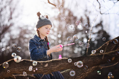 Young Girl Blowing Bubbles Outdoors in Fall - CAVF90090