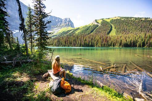 Wanderer sitzt am Rawson Lake mit Blick auf den Sarrail-Rücken in den Rocky Mountains - CAVF90100
