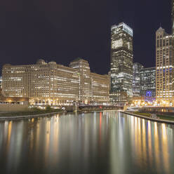 Beleuchtete Gebäude am Fluss bei Nacht, Chicago, USA - AHF00164