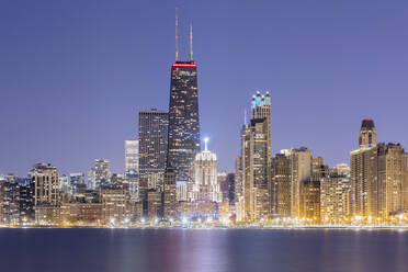 Beleuchtete Ansicht der 875 North Michigan Avenue (John Hancock Center) umgeben von Wolkenkratzern in der Abenddämmerung, Chicago, USA - AHF00171