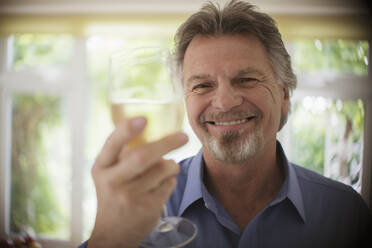 Nahaufnahme Porträt glücklicher sorgloser älterer Mann trinkt Weißwein - CAIF29857