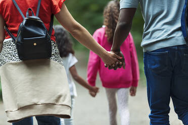 Liebevolle Familie, die Händchen hält und auf dem Weg geht - CAIF29925