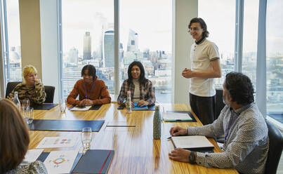 Businessman leading conference room meeting in highrise office - CAIF29951