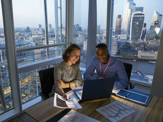 Business people working at laptop in highrise office, London, UK - CAIF29970