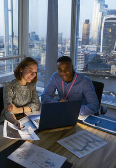 Business people working at laptop in highrise office, London, UK - CAIF29971