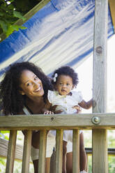 Portrait happy mother and daughter daughter on playground set - CAIF30000