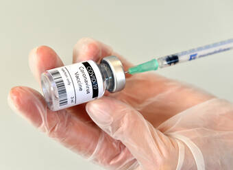 Coronavirus COVID-19 Impfstoff Flasche, Fläschchen, Behälter, in der Hand wi - CAVF90147
