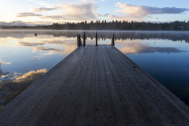 Holzsteg mit Leiter am See bei Sonnenuntergang und Spiegelung der Wolken - CAVF90169