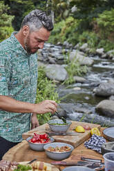 Küchenchef bereitet Chimichurri von Scratch auf dem Campingplatz Picknick-Barbecue zu - CAVF90185