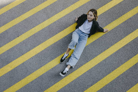 Young woman sitting on street stock photo