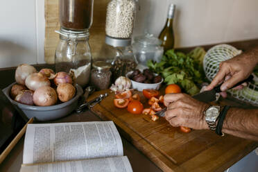 Cropped Bild der menschlichen Hand Schneiden von Tomaten in der Küche zu Hause - VABF03649