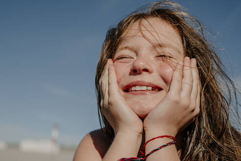 Girl with hand on chin during sunny day - OGF00607