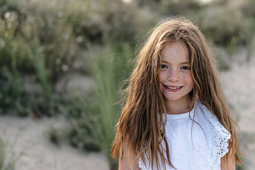 Brown hair girl standing at beach on sunny day - OGF00618