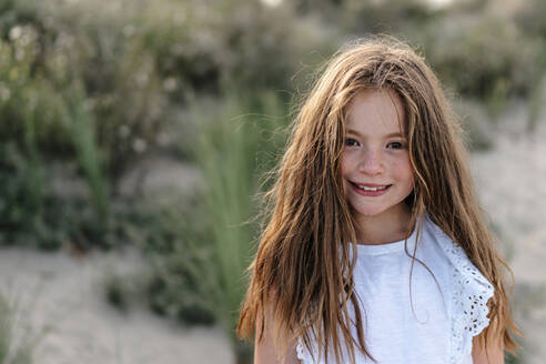 Braunhaariges Mädchen am Strand stehend an einem sonnigen Tag - OGF00618
