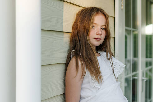 Girl leaning on wall during sunny day - OGF00620