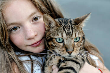 Niedliches Mädchen mit Katze an einem sonnigen Tag - OGF00623