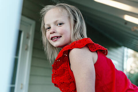 Smiling girl standing against residential building stock photo