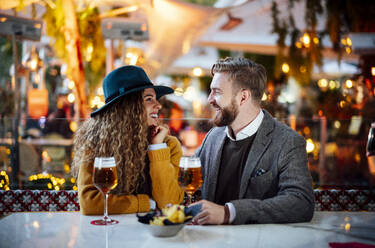 Couple talking while sitting at beer garden in city - OCMF01816