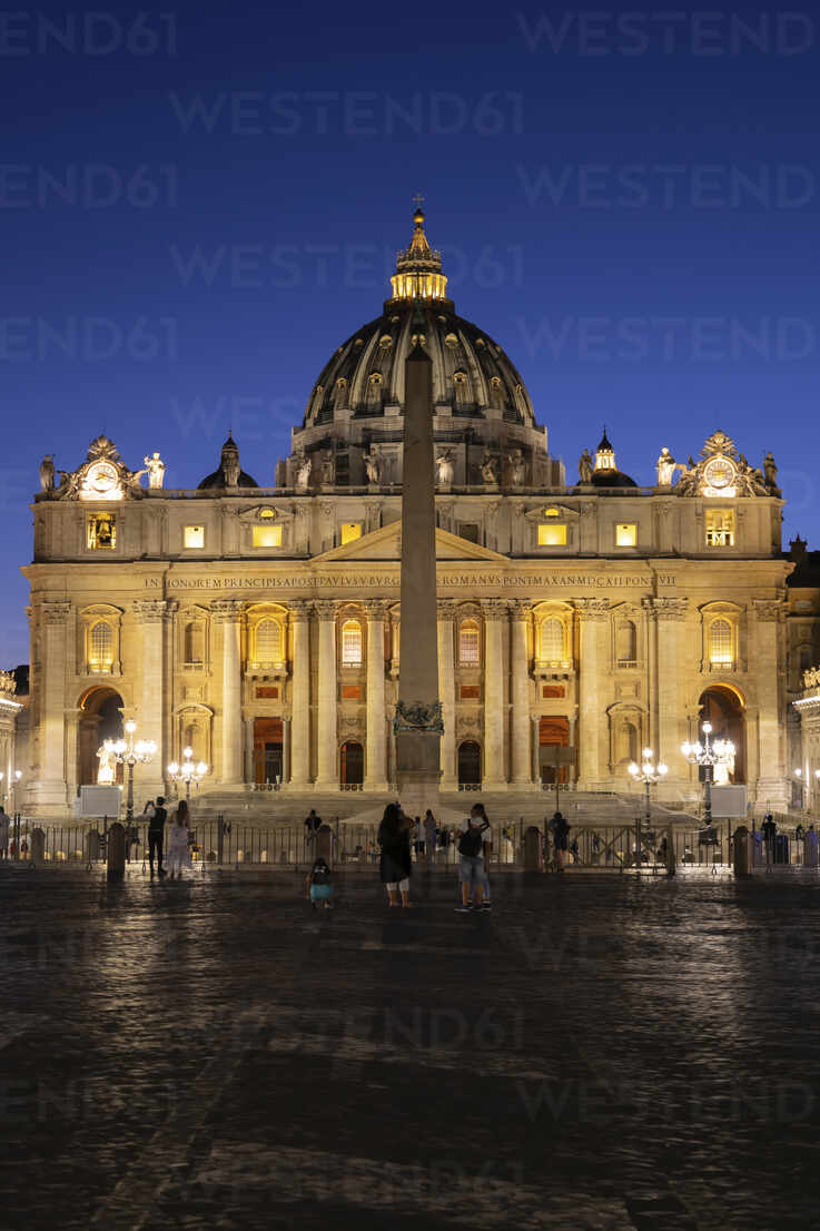 Tourists at St. Peter's Square with illuminated St. Peter's
