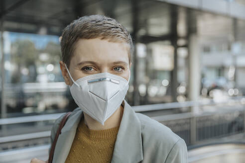 Woman wearing protective face mask standing in city - MFF06718